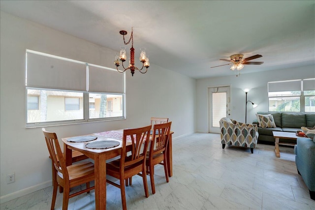 dining space with ceiling fan with notable chandelier