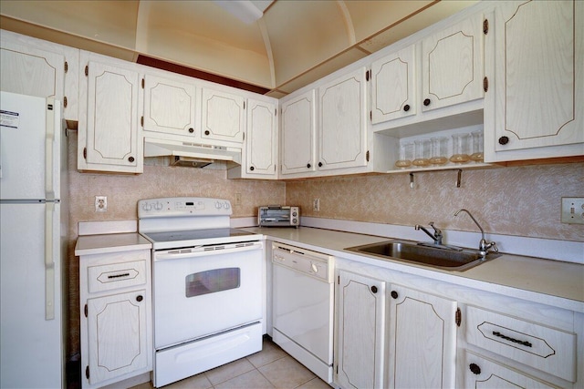 kitchen with white cabinets, sink, light tile patterned floors, white appliances, and tasteful backsplash