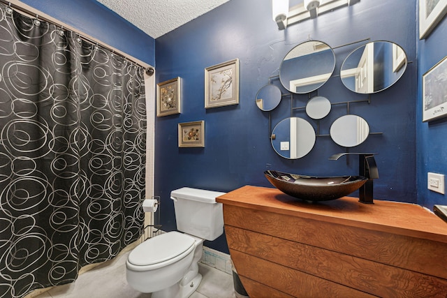 bathroom with vanity, walk in shower, tile patterned floors, toilet, and a textured ceiling