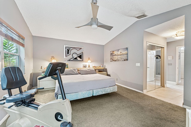 carpeted bedroom featuring ceiling fan, a textured ceiling, a closet, and lofted ceiling