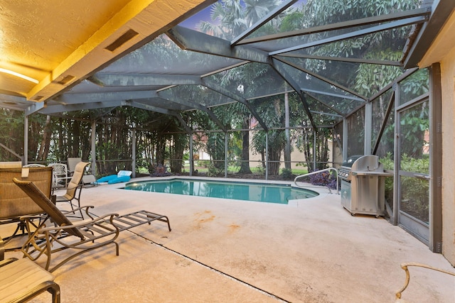 view of swimming pool featuring a grill, glass enclosure, and a patio area