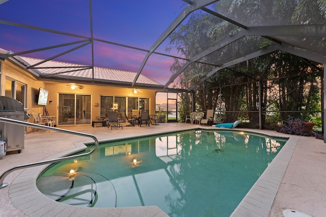 view of swimming pool featuring glass enclosure, a patio, and grilling area