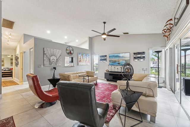 living room with light tile patterned flooring, high vaulted ceiling, ceiling fan, and a textured ceiling