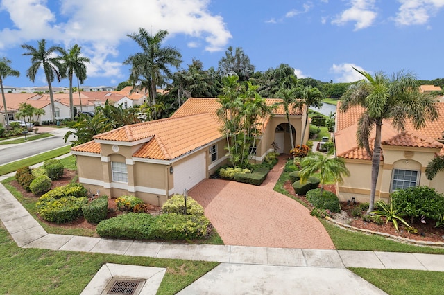 mediterranean / spanish home featuring a garage and a front lawn