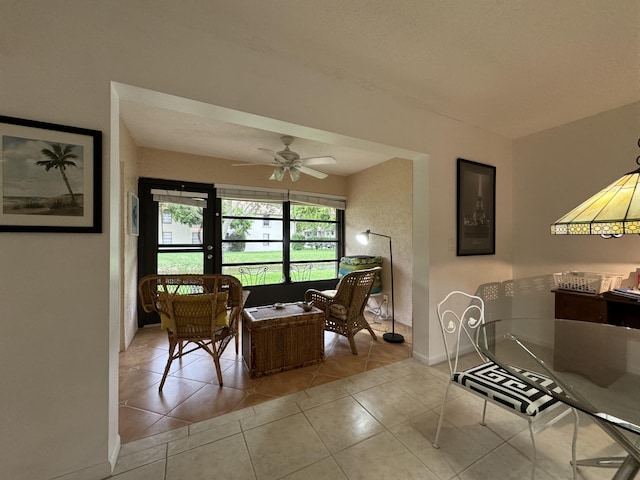 tiled dining space with ceiling fan