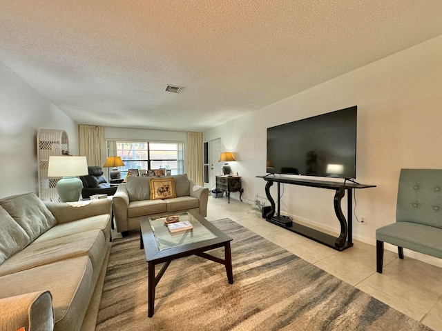 tiled living room featuring a textured ceiling