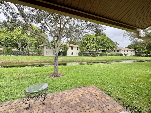 view of yard with a water view and a patio area