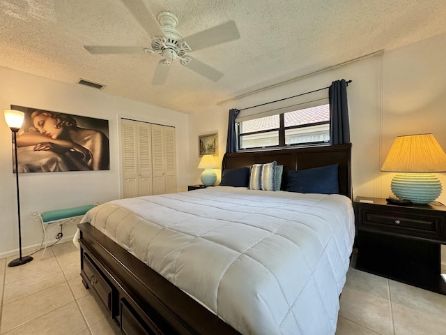 bedroom with a textured ceiling, light tile patterned flooring, and visible vents