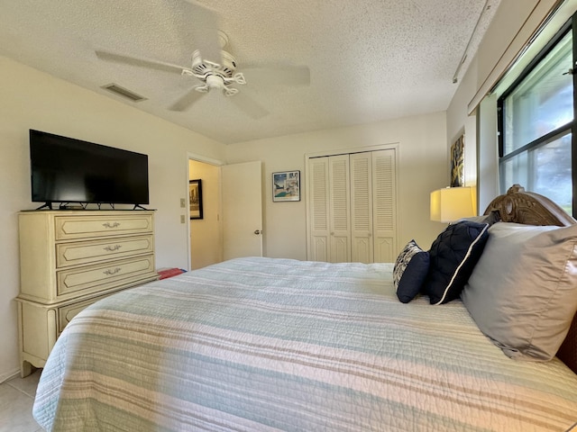 bedroom with visible vents, a ceiling fan, a textured ceiling, and a closet