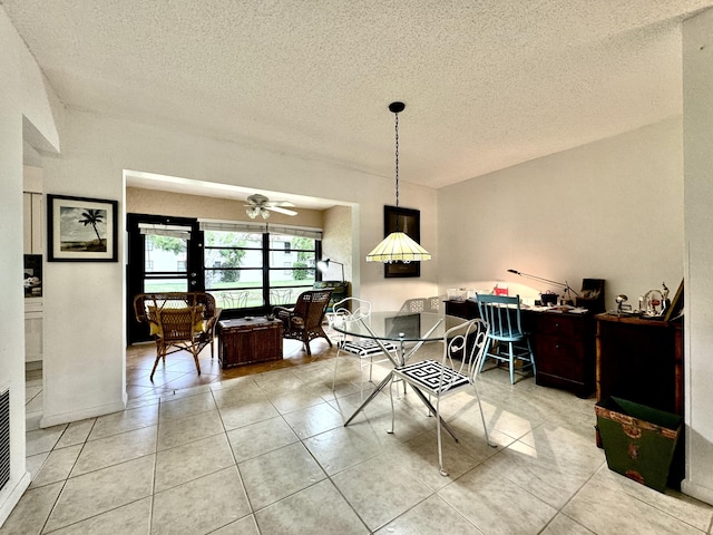 dining space featuring light tile patterned floors, a ceiling fan, and a textured ceiling