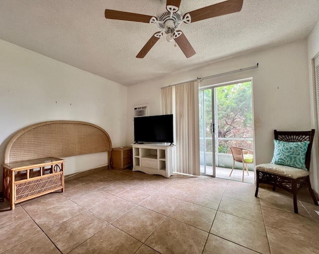 sitting room featuring tile patterned floors, ceiling fan, and a textured ceiling