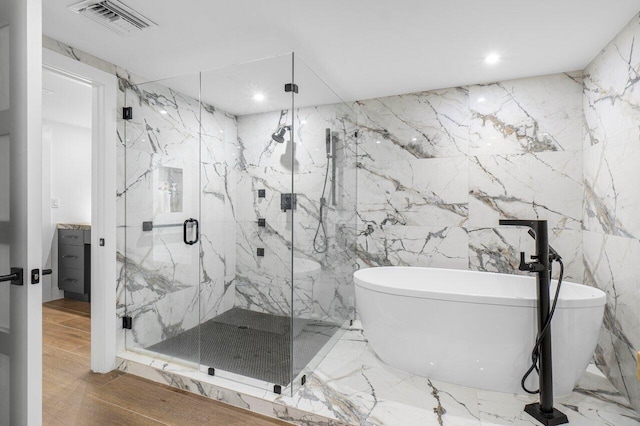 bathroom with tile walls, vanity, and plus walk in shower