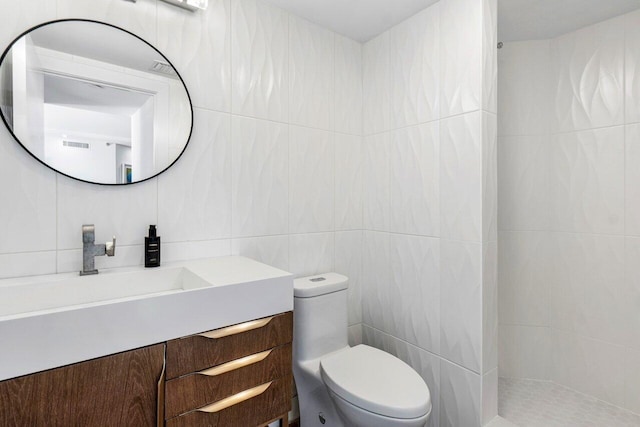 bathroom with backsplash, vanity, a shower, toilet, and tile walls