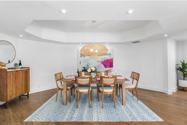 dining room featuring dark hardwood / wood-style floors and a raised ceiling