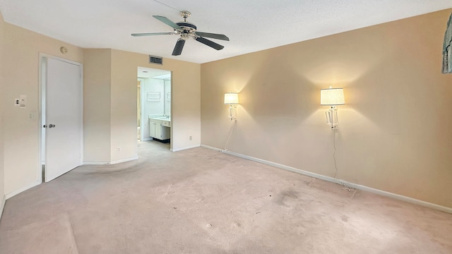 carpeted empty room with ceiling fan and a textured ceiling