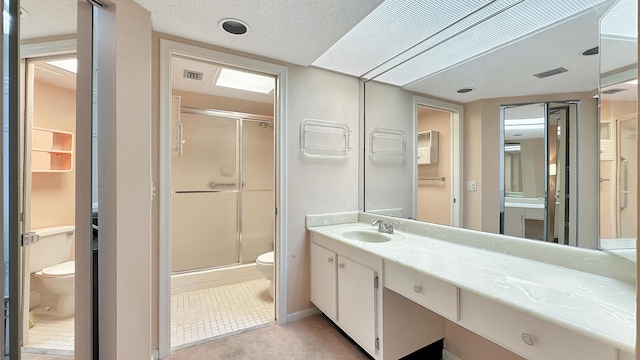 bathroom featuring an enclosed shower, vanity, a textured ceiling, and toilet