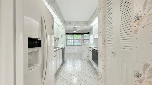 kitchen with light tile patterned floors, range with electric cooktop, white refrigerator with ice dispenser, and stainless steel dishwasher