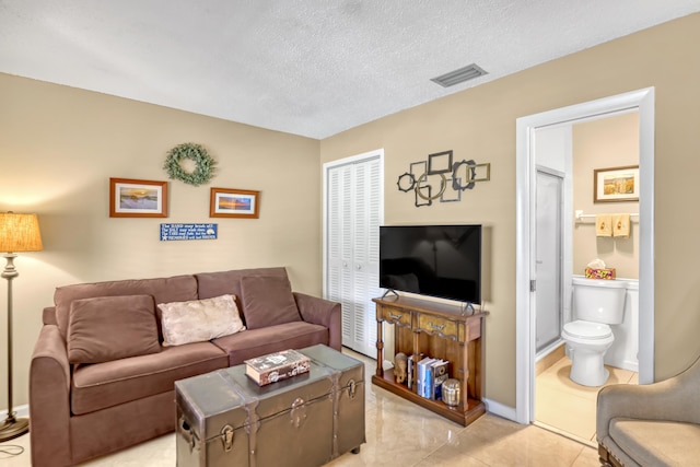 living room featuring light tile patterned flooring and a textured ceiling