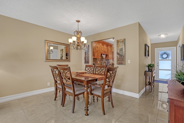 tiled dining area with a notable chandelier and a textured ceiling