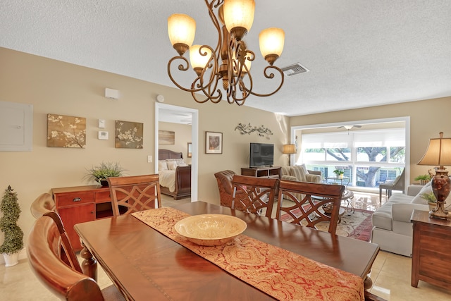 dining room with a textured ceiling, light tile patterned flooring, and ceiling fan with notable chandelier