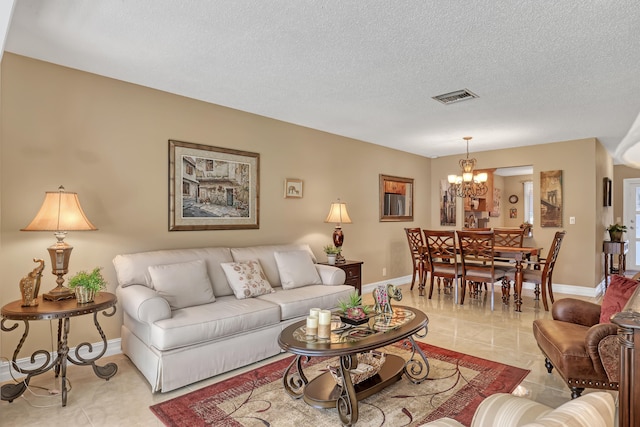 living room with a chandelier, a textured ceiling, and light tile patterned floors