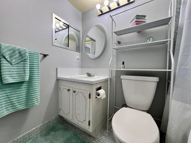 full bathroom featuring vanity, shower / bath combo with shower curtain, toilet, and tile patterned flooring