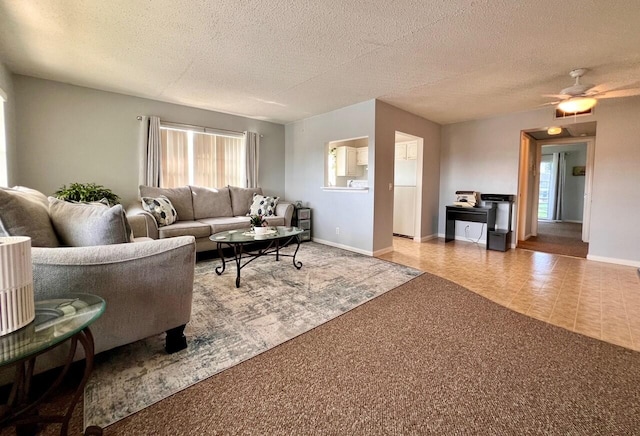 carpeted living room with a textured ceiling and ceiling fan