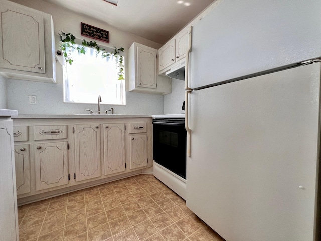 kitchen featuring light countertops, range with electric cooktop, a sink, and freestanding refrigerator