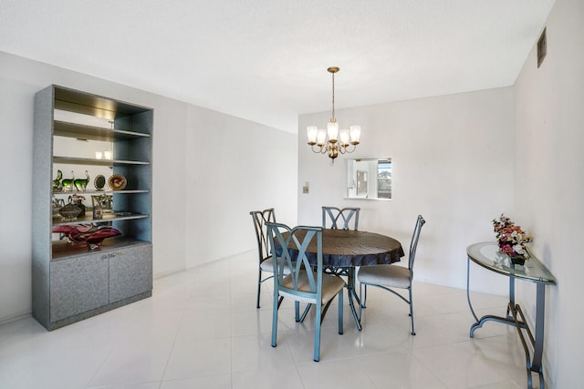 dining area with a notable chandelier, light tile patterned flooring, and built in features