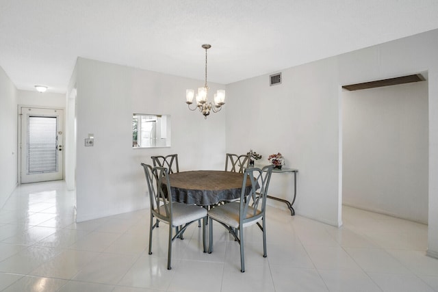 dining room with light tile patterned floors and a chandelier