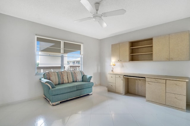 interior space with light tile patterned flooring, a textured ceiling, and ceiling fan