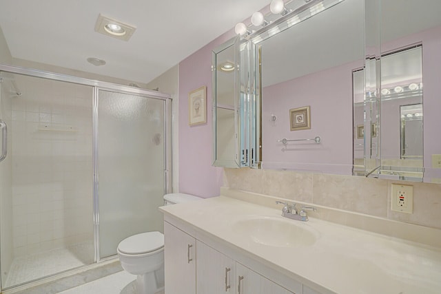 bathroom featuring toilet, a shower with shower door, vanity, and tile patterned flooring