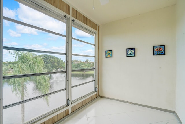 unfurnished sunroom featuring a water view and ceiling fan