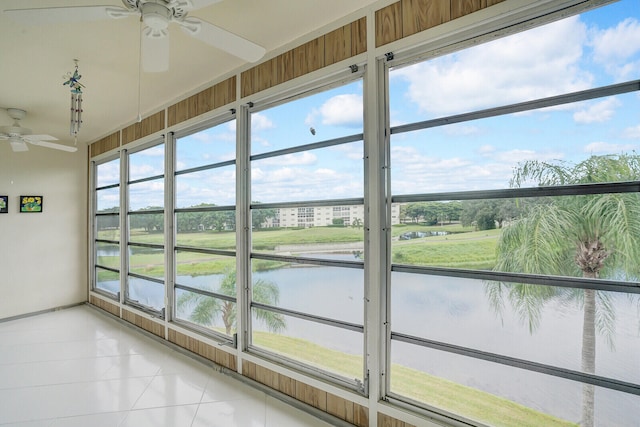 unfurnished sunroom with a water view and ceiling fan