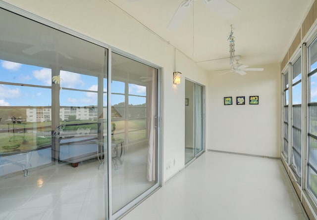 unfurnished sunroom with a wealth of natural light and ceiling fan