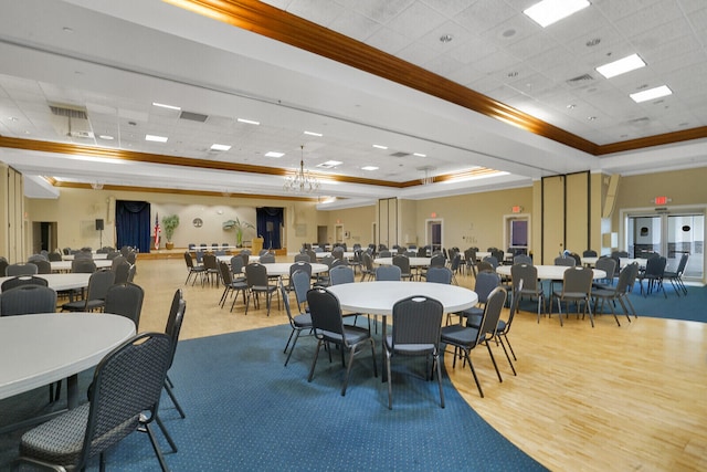 dining space with ornamental molding, hardwood / wood-style flooring, a paneled ceiling, and a raised ceiling