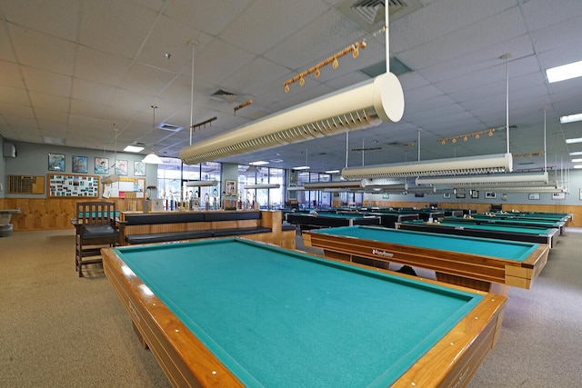 recreation room featuring light carpet and wood walls