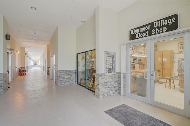 hall with french doors and tile walls