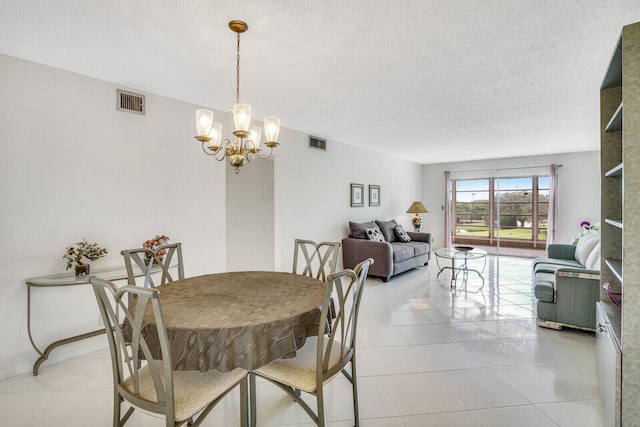 tiled dining room featuring a textured ceiling and an inviting chandelier