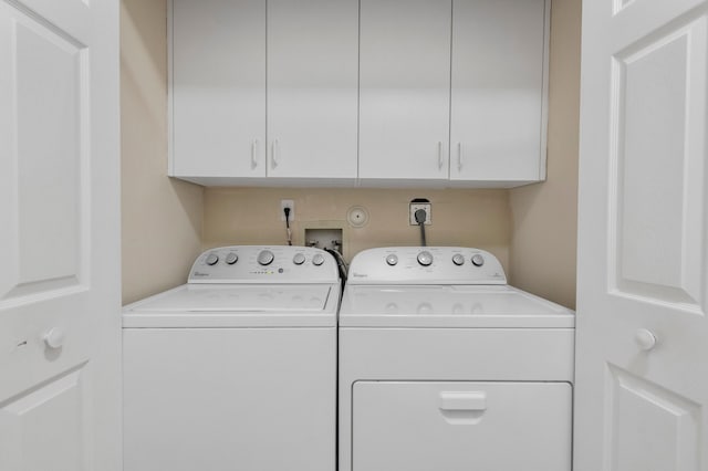 washroom featuring independent washer and dryer and cabinet space