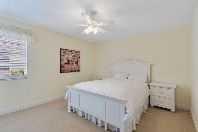 bedroom with ceiling fan, a textured ceiling, and light colored carpet