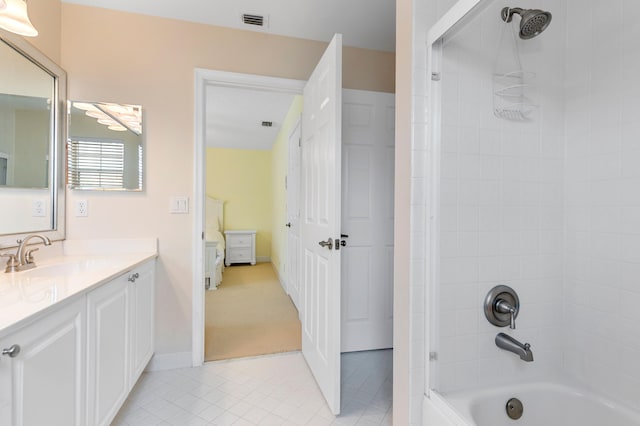 bathroom with vanity, tiled shower / bath combo, and tile patterned flooring