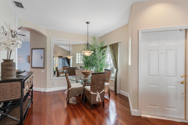 dining area featuring a textured ceiling, a wealth of natural light, and dark hardwood / wood-style floors