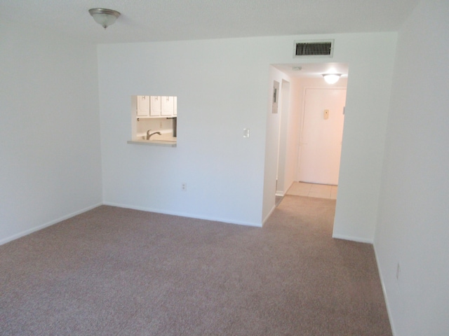 spare room featuring light colored carpet