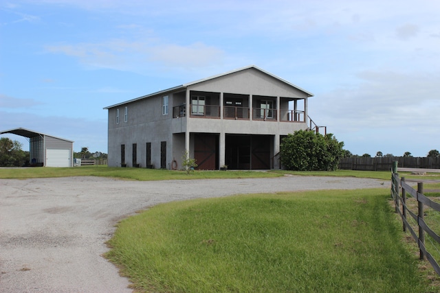 view of front of house featuring a balcony and a front yard