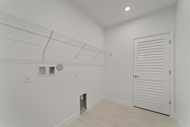 laundry area featuring electric dryer hookup, hookup for a washing machine, light wood-type flooring, and gas dryer hookup