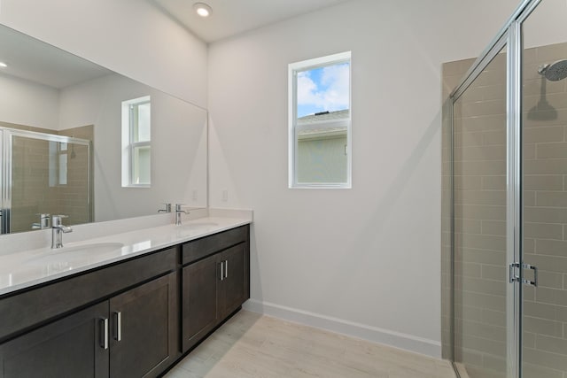 bathroom with hardwood / wood-style flooring, vanity, and an enclosed shower