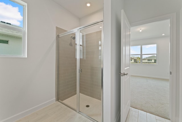 bathroom featuring hardwood / wood-style flooring and a shower with shower door