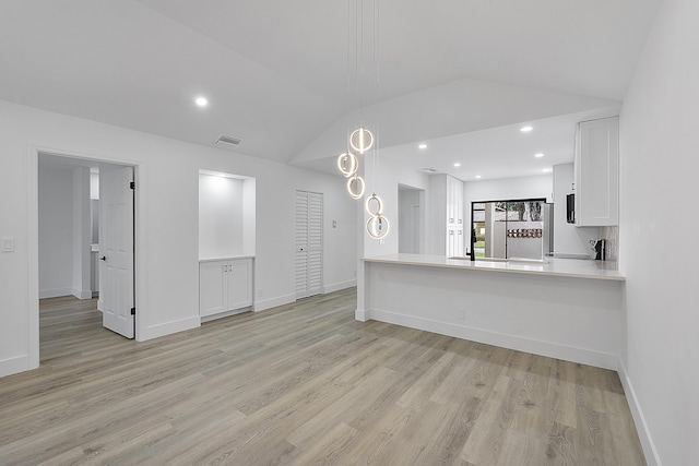 unfurnished living room with lofted ceiling and light hardwood / wood-style floors