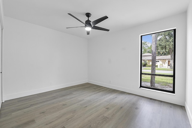 spare room featuring hardwood / wood-style flooring, a wealth of natural light, and ceiling fan